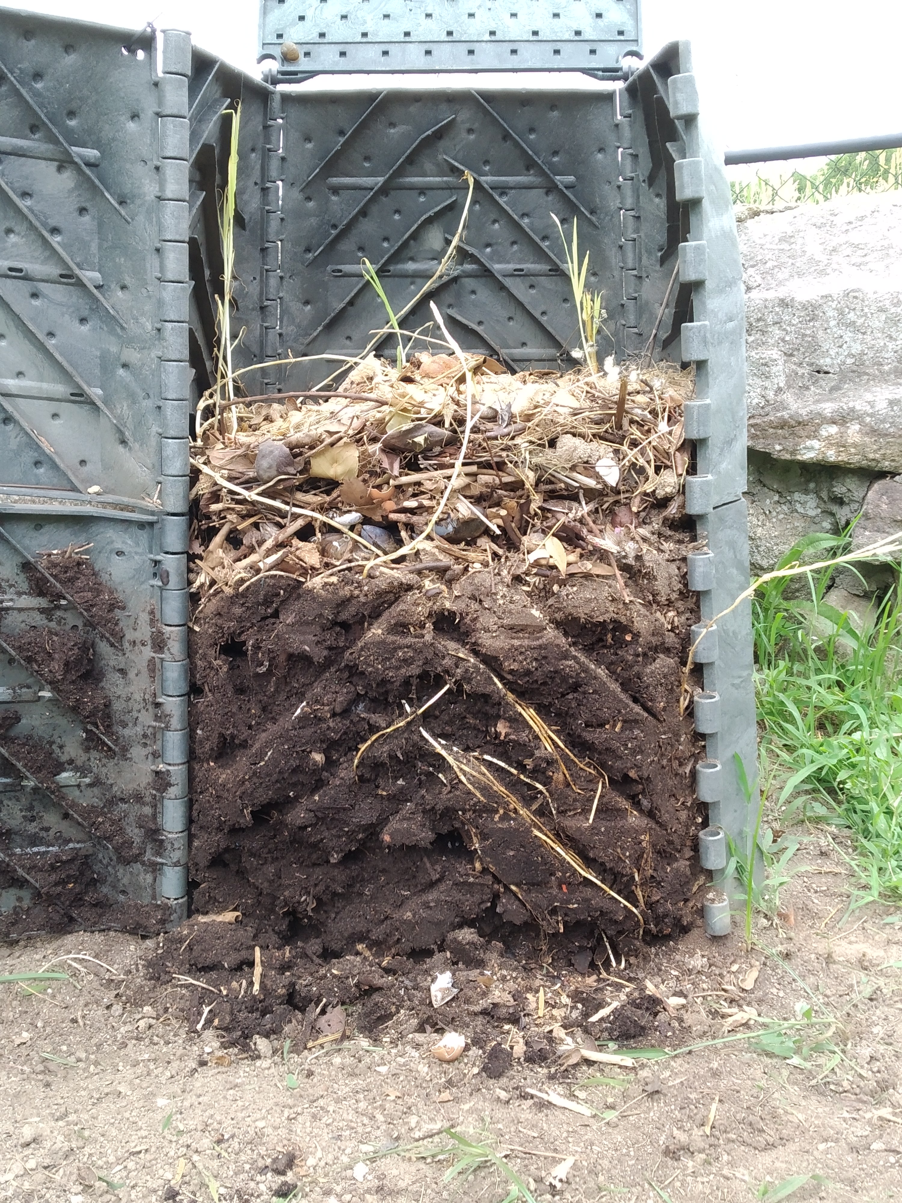 Side view of an open composting bin.