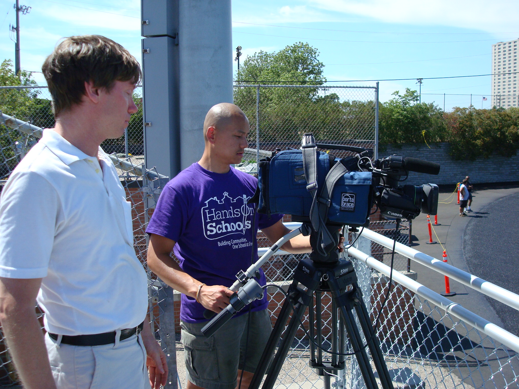 Two SPNN workers setting up cameras for the Rondo Days Drill Team Competition, an event that is broadcast on-location.