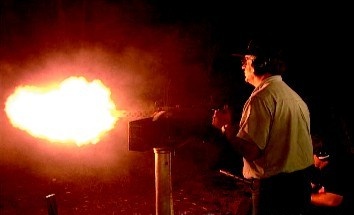 A machine gun being fired at night during the Machine Gun Shoot event.