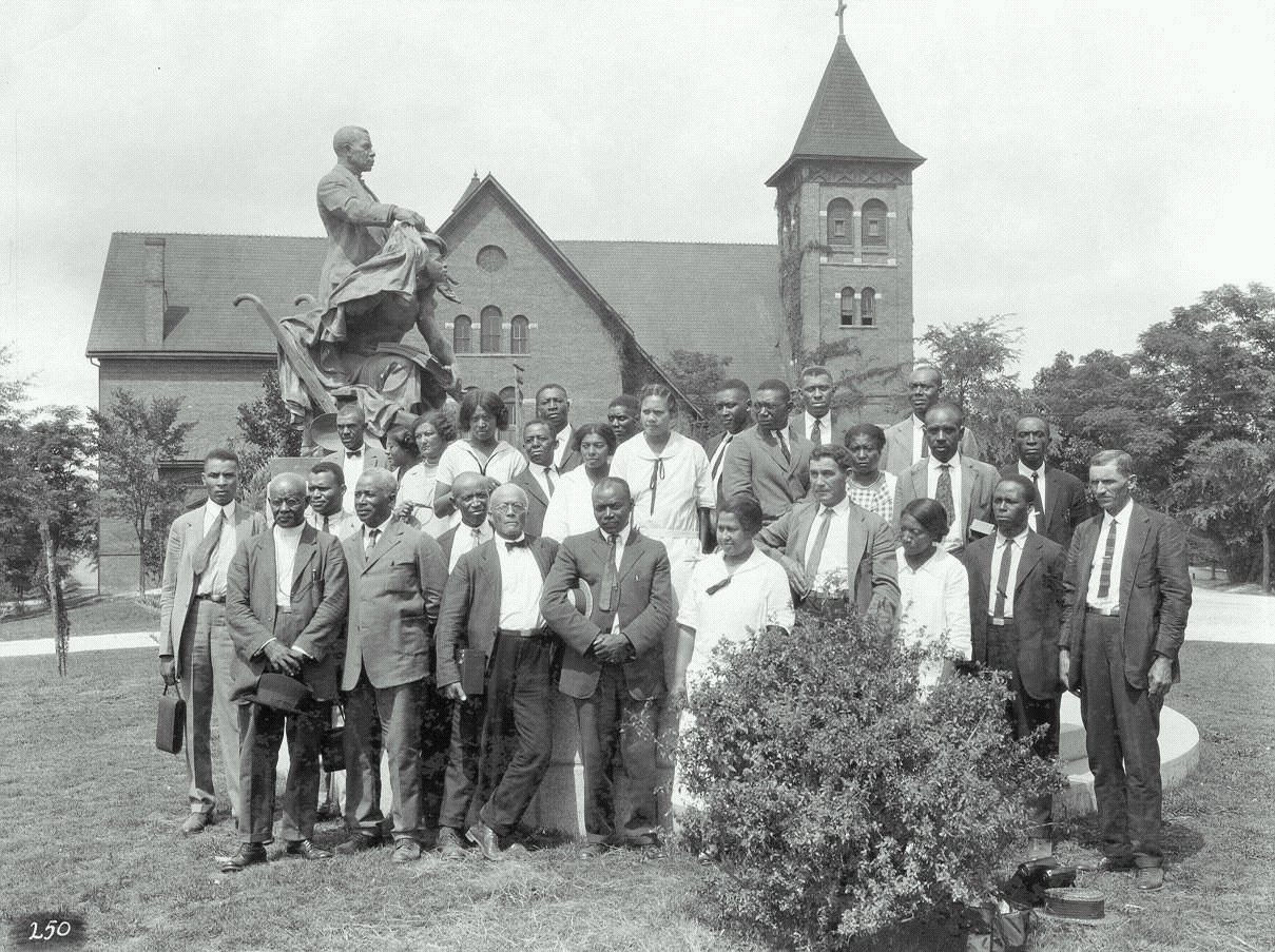 African-American farm and home demonstration agents pose for a group photograph under the Booker T. Washington monument at Tuskegee Institute, July 15, 1925.