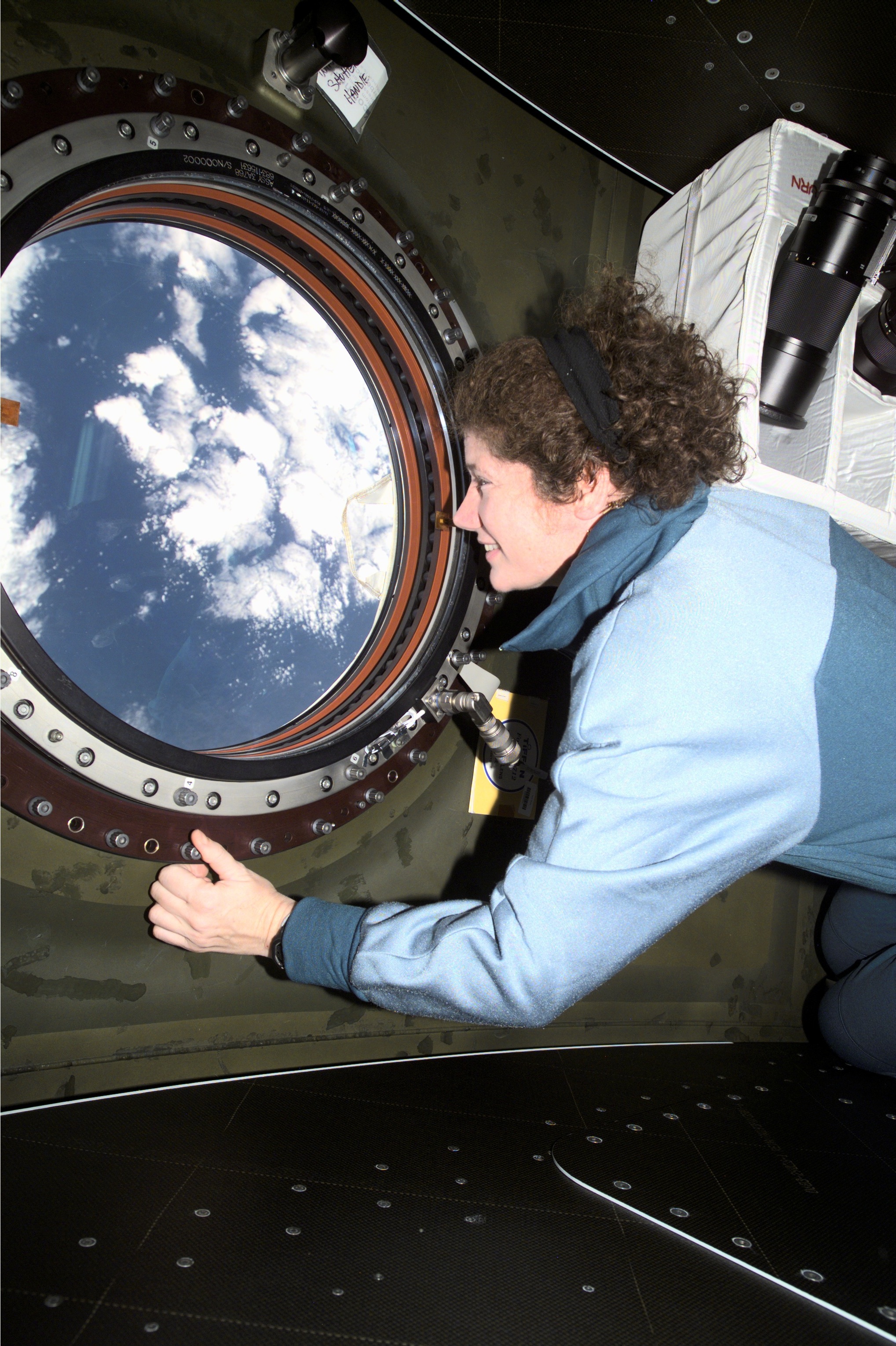 Astronaut Susan J. Helms looking out the window that will be used for AgCam imagery
