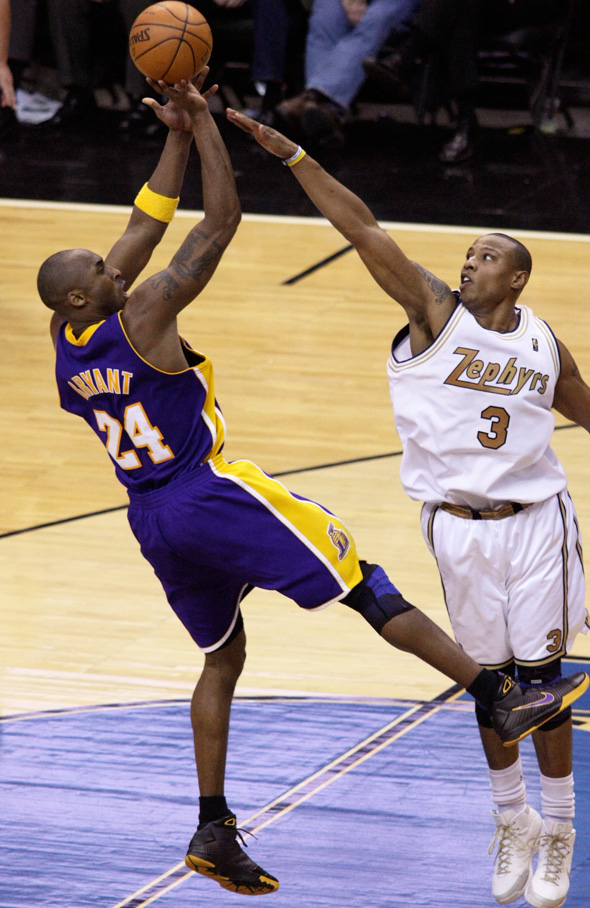 Bryant scored 50 points or more in four consecutive games in 2007.|alt=A black basketball player, wearing a jersey with a word "BRYANT 24" on the back, tries to shoot a ball behind another black player, wearing a jersey with a word "ZEPHYRS 3" in the front.