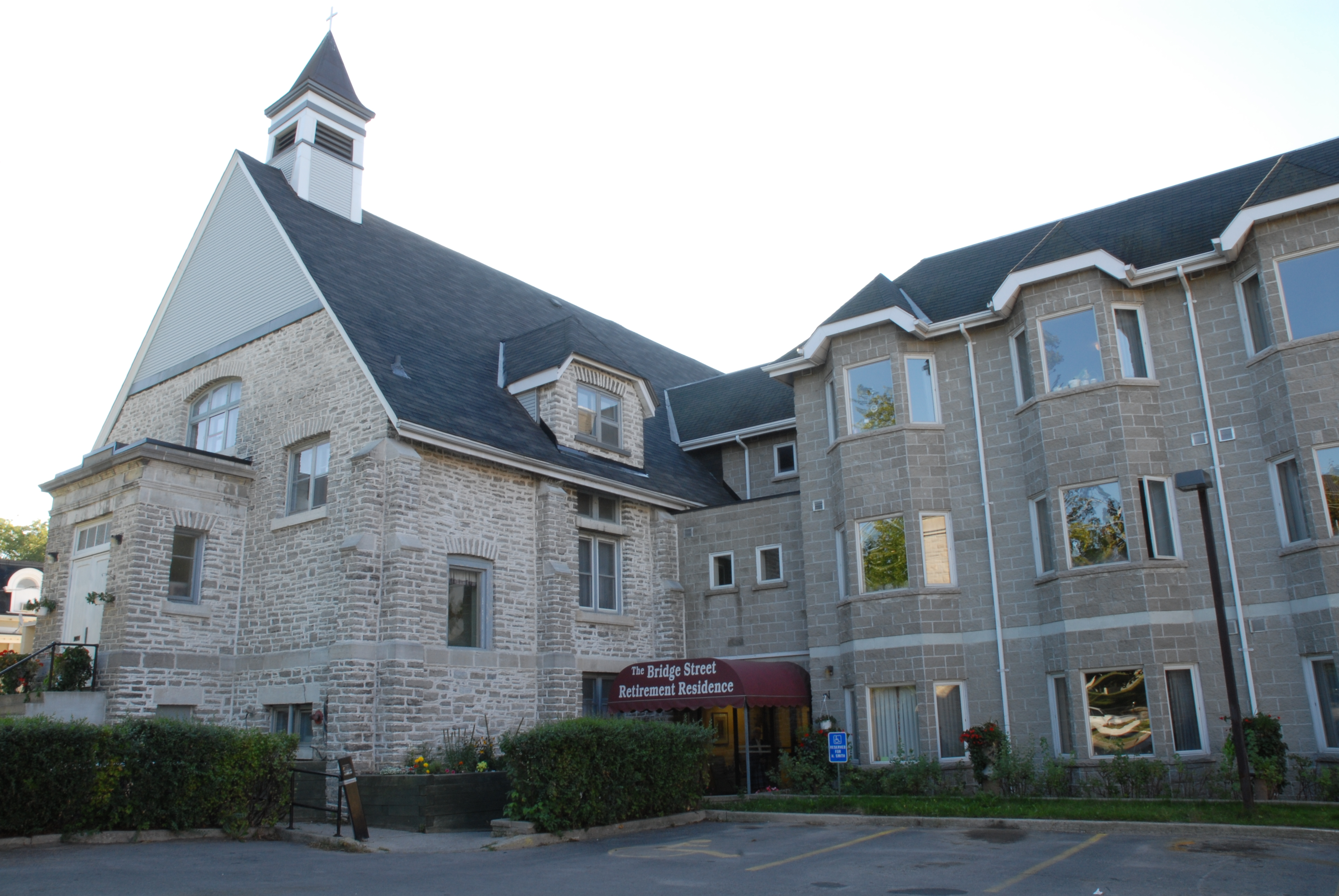 text| A shot from the front of the Bridge Street Retirement Residence, shows the original Parish Hall structure now used as the common area