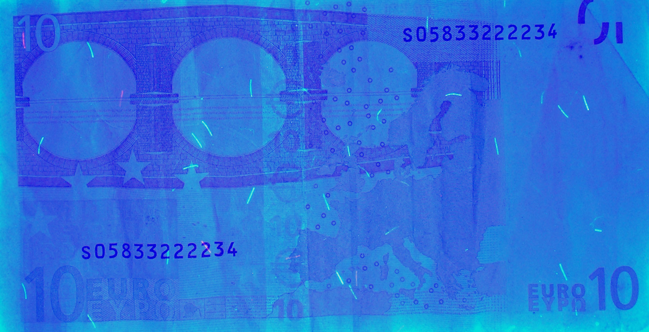 Example of UV image of a Euro banknote. It is possible viewing the security metallic fibers randomly distributed.