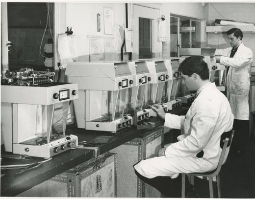 Torbal employees inspecting a line of scales in the laboratory