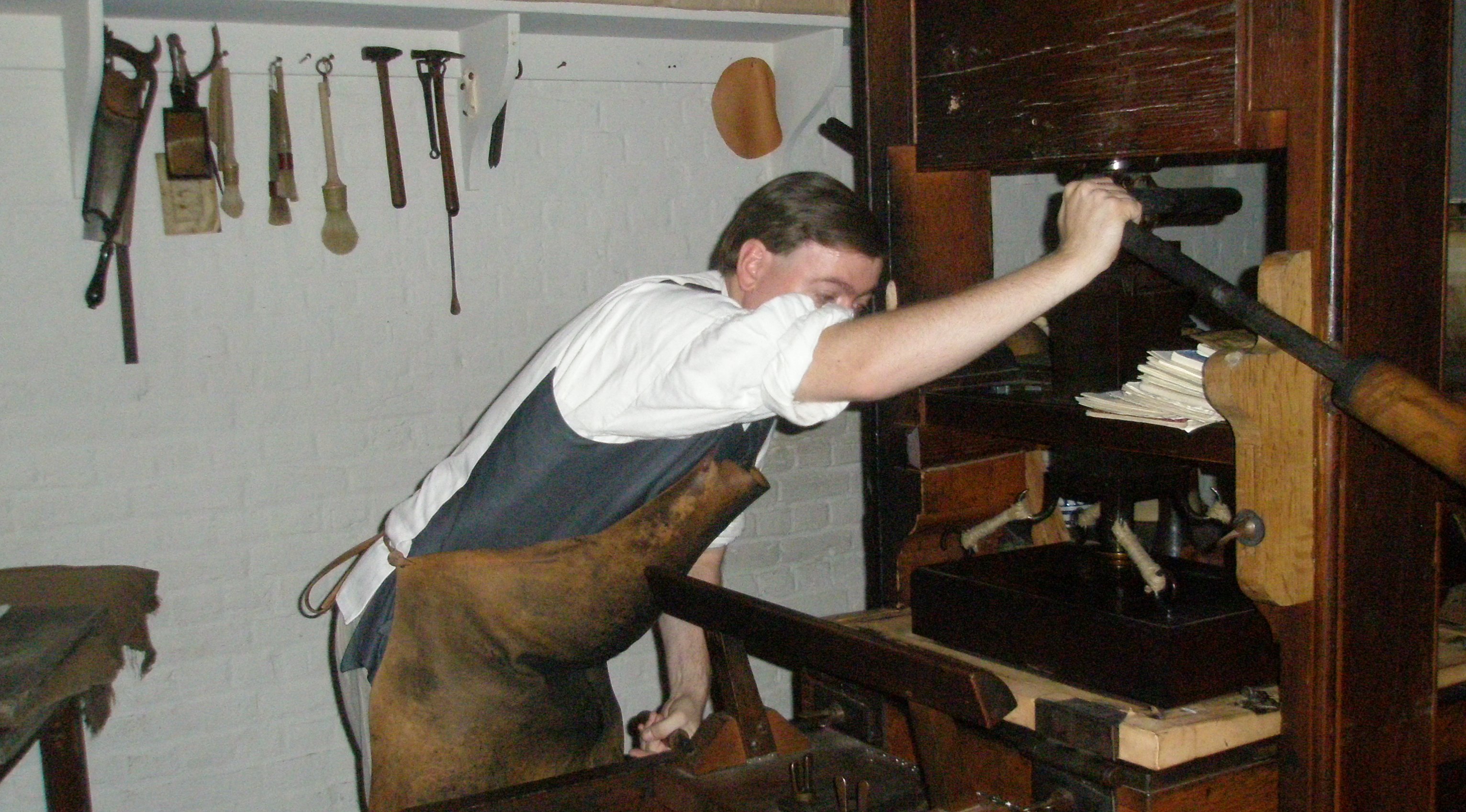 A "puller" operating a printing press