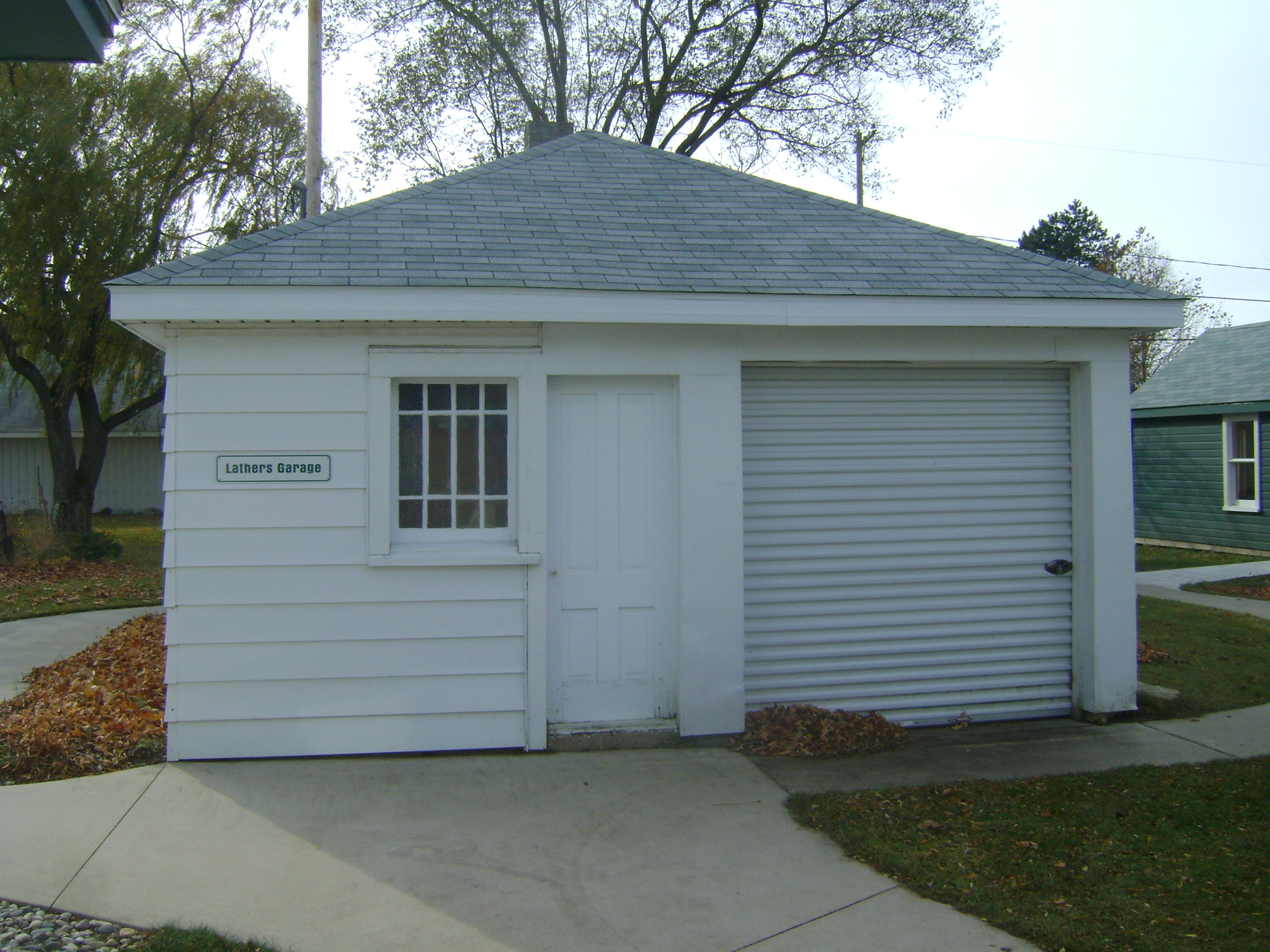 Lathers' home garage with outhouse