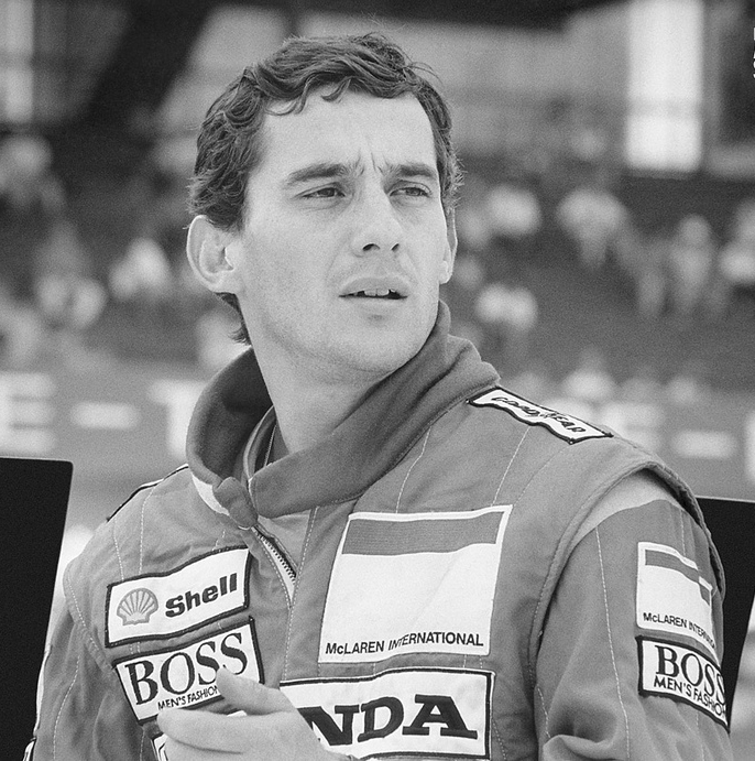 Ayrton Senna won 41 Formula One races and three world championships before his death in 1994.|alt=Black and white photograph of Senna