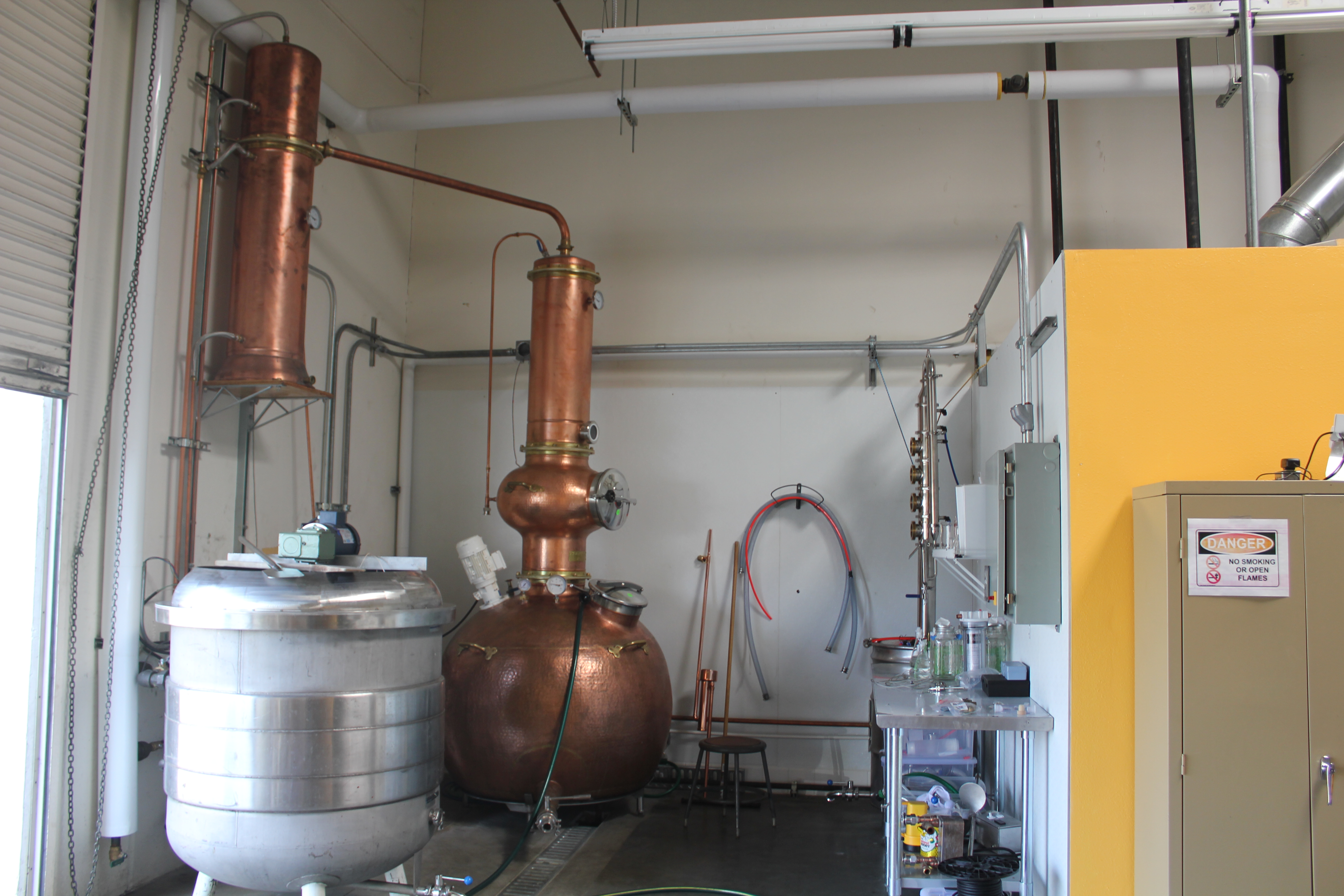 The Still area. 7BBL Kettle/Mash/Lauter tun, 1000L Hoga pot still, far right is a 55G Pot with Dragon Still Components used by Stark Spirits Distillery of Pasadena, California.|left