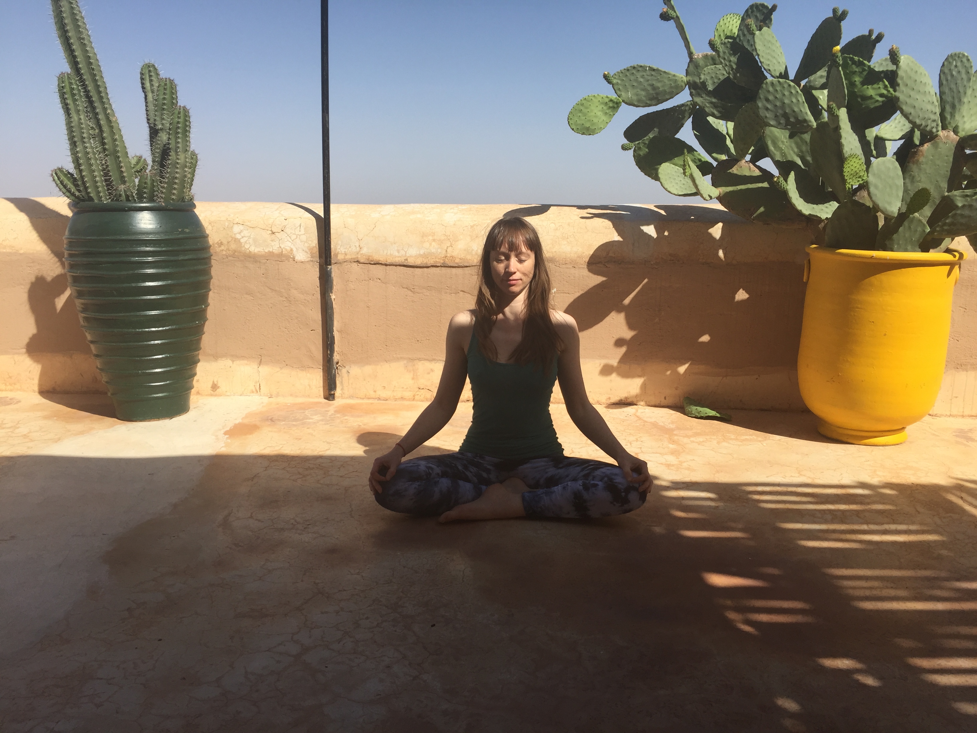 Khadine practicing Siddhasana near some cacti