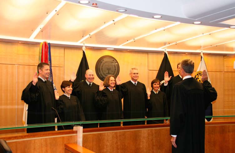 Swearing in judges on the Court of Military Commission Review. John Rolph swears in Paul Holden, Dawn Scholz, Steven Walburn, Amy Bechtold, Steven Thompson, Lisa Schenck, and Eric Geiser.